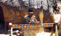 Eine Xhosa Frau beim Flechten