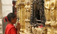 Eine Frau betet an einem der zahllosen Tempel der Stadt
