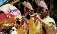 Moenche spielen auf dem Dungchen (Tibetanische Trompete).